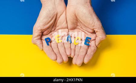 man holding a peace inscription in the colors of the ukrainian flag Stock Photo