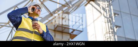 Cheerful male worker talking on cellphone outdoors at factory Stock Photo