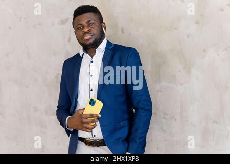 Portrait of smart afro american man businessman leader staying near desk and yellow laptop, smiling and cross hands ready decide solution wear suit is Stock Photo