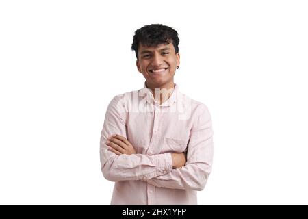 Young peruvian man smile wearing a pink shirt stand with arms crossed, isolated. Stock Photo