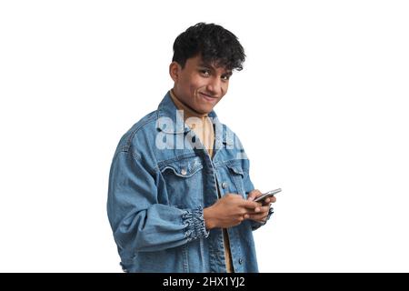 Young peruvian man using smartphone and looking at camera, isolated. Stock Photo
