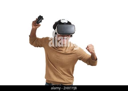 Young peruvian man playing games with joystick and vr headset, isolated. Stock Photo