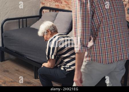 caucasian elderly pensioner lady collapses after a quarrel with her middle-aged son. High quality photo Stock Photo