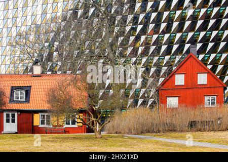 Traditional Swedish red timber house in front of modern Aula Medica, Karolinska Institute in Solna, Stockholm Sweden. Stock Photo