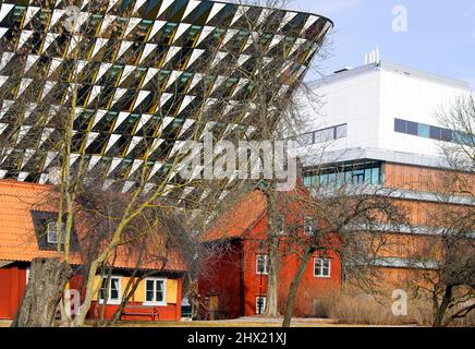 Traditional Swedish red timber house in front of modern Aula Medica, Karolinska Institute in Solna, Stockholm Sweden. Stock Photo