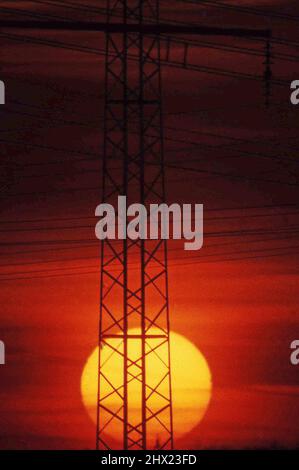 Setting Sun Behind Power Pole Stock Photo