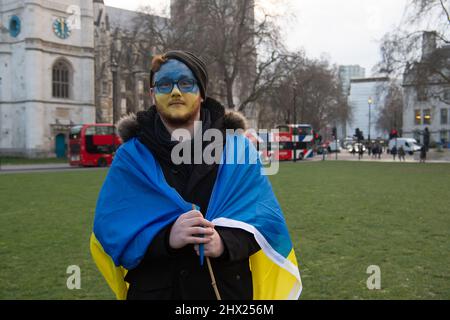 Westminster, London, UK. 8th March, 2022. A group of colleagues holding Ukrainian flags gather outside Parliament protesting against the Russian invasion of Ukraine. Credit: Maureen McLean/Alamy Live News Stock Photo