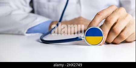 Ukraine medical help and support - doctor holding stethoscope with Ukraine flag Stock Photo