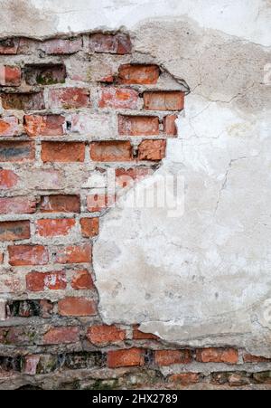 Old wall with brickwork under plaster Stock Photo