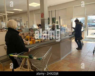 Waitrose Rushden Lakes Northamptonshire UK wait waiting serve to be customer customers food collect pay staff mask masks screen plastic glass waiting Stock Photo