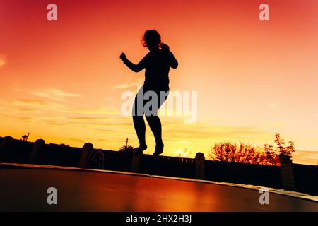 Silhouette of a young sexy nude woman with big beautiful breasts lies