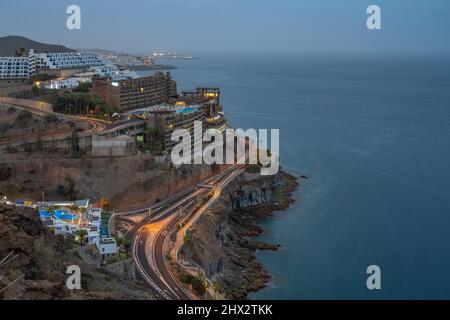 View of coastal road and hotels near Puerto Rico at dusk, Playa de Puerto Rico, Gran Canaria, Canary Islands, Spain, Europe Stock Photo