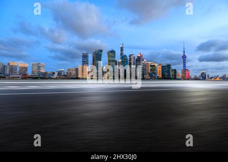 Motion blurred asphalt road and city skyline with modern commercial buildings in Shanghai, China. Stock Photo