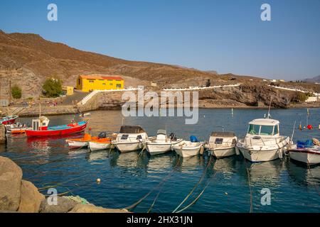 View of colourful boats in harbour and mountains in background, Puerto de La Aldea, Gran Canaria, Canary Islands, Spain, Europe Stock Photo