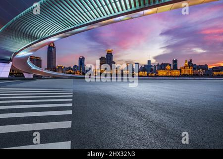 Asphalt road and city skyline with modern commercial buildings in Shanghai at night, China. Stock Photo
