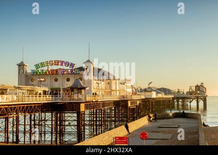 13 January 2022: Brighton, East Sussex UK - Brighton Palace Pier, with late afternoon walkers enjoying the winter sunshine. Stock Photo