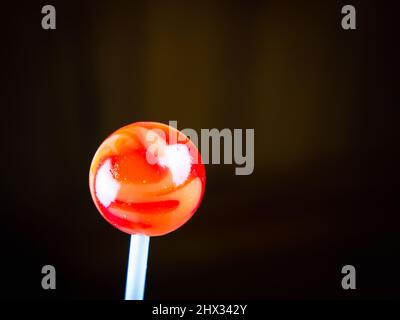 Red round caramel candy on a stick Stock Photo