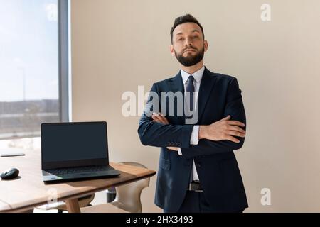 company manager in a blue suit demonstrates a laptop screen Stock Photo