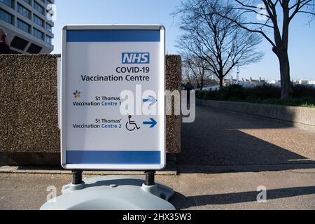 London, UK. 8th March, 2022. An NHS Covid-19 Vaccination Centre sign at St Thomas' Hospital in London. Postive Covid-19 cases int he UK were up 22,900 compared with last week. The number of people in hospital with Covid is up 471 on last week and the number of deaths of 212 are up 18 on last week . Credit: Maureen McLean/Alamy