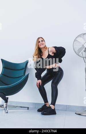 Slim woman dressed in tight leggings and top feeling thirsty after