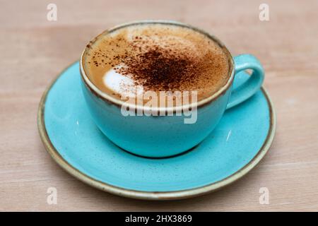 Cappuccino in turquoise coffee cup Stock Photo