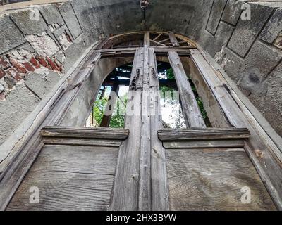 Wooden door to abandoned ruined building. Bottom view. Stock Photo