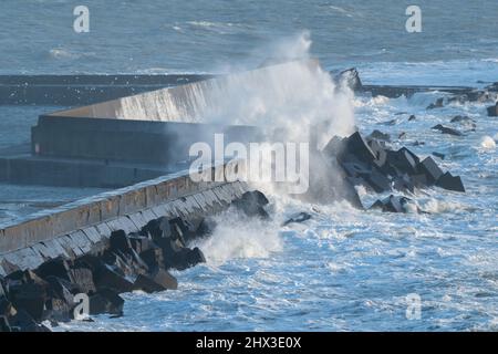 Big waves hit concrete wall in the port of Helgoland island, North sea, Germany. Windy day of winter in German archipelago. Stock Photo