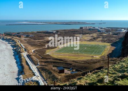 Football field in the island of Helgoland, Germany, with the island of Dune in the background on a beautiful sunny day of winter. Stock Photo