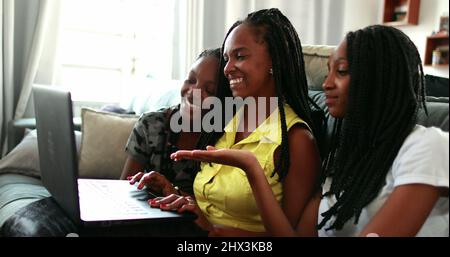 Mother and teenage daughters waving hello to laptop webcame. Family ...