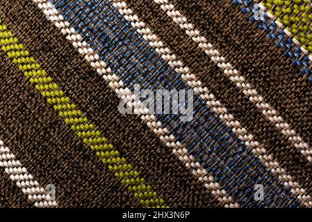 The texture of a dense upholstery fabric with straight multi-colored lines and stripes. Fabric background. pattern Stock Photo