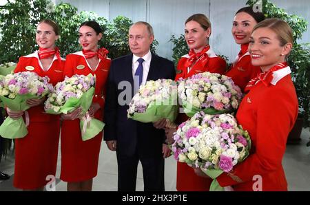 Moscow, Russia. 05 March, 2022. Russian President Vladimir Putin poses with Aeroflot flight attendants during a lunch with female flight crews at the Aeroflot aviation training complex, March 5, 2022 in Moscow, Russia. Aeroflot is suspending most international flights out of fear of having their aircraft impounded. Stock Photo