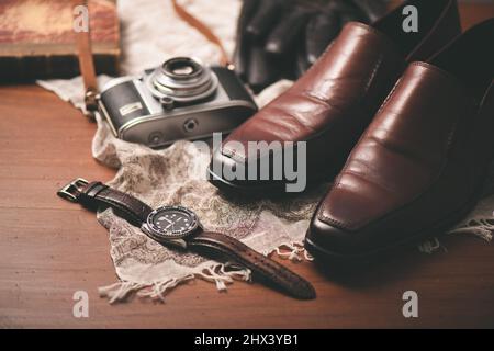 Men accessories on wooden desk. Closeup at luxury men watch with black dial and leather strap. Stock Photo