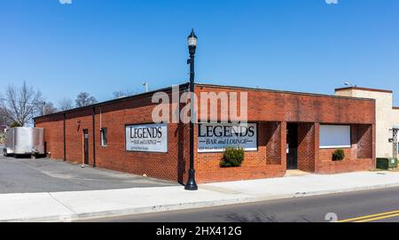 GASTONIA, NC, USA-3 MARCH 2022: The Legends Bar and Lounge on W. Main St.  View of front left corner, showing painted signs and entire building. Stock Photo