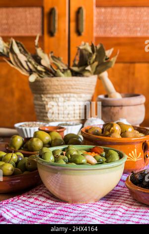 Still life with different varieties of olives, presented in bowls, dressed with different traditional dressings. Traditional homemade dressings, typic Stock Photo