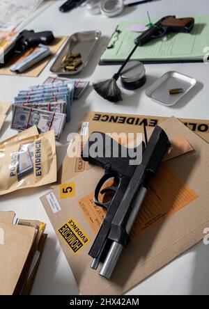 Money and weapons in crime lab for investigation, conceptual image Stock Photo
