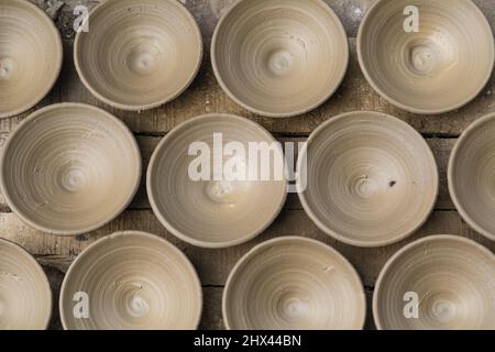 Many earthen pots or clay pots are kept for drying in the sun in the workshop. Stock Photo
