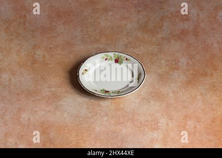 Classic plate isolated and hand-painted with decorative vineyard elements on a background of textured marble, and pastel color with some splattered pa Stock Photo