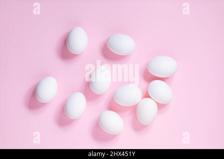 White easter eggs on pink background. Top view. Different shapes like easter bunny made from white eggs. Happy Easter simple concept Stock Photo