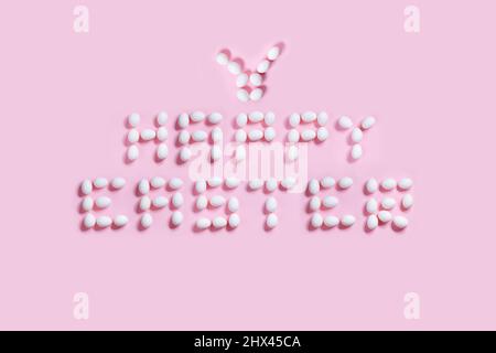 Happy Easter postcard written from  white eggs on a pink background, ideal for illustration and various use Stock Photo