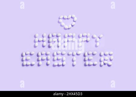 Happy Easter postcard written from  white eggs on a purple background, ideal for illustration and various use Stock Photo