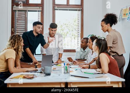 All on board for business success. Shot of a group of young businesspeople having a meeting in a modern office. Stock Photo