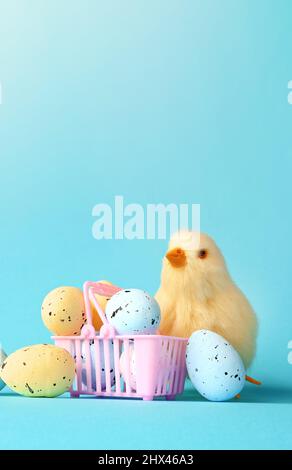 Easter eggs and yellow chick on a blue background. The minimal concept. Easter card. Stock Photo