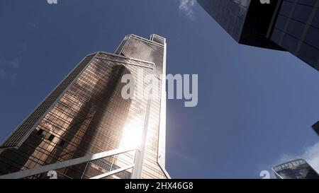 Modern office buildings with glass facade. Bottom view of new business center, modern district in a big city on blue sky background. Stock Photo