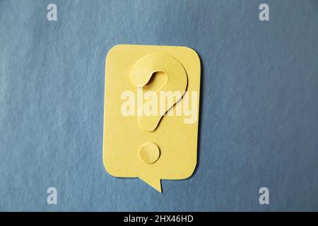 Question mark on yellow speech bubble, gray background. Problem and solution concept. Brainstorm. Stock Photo