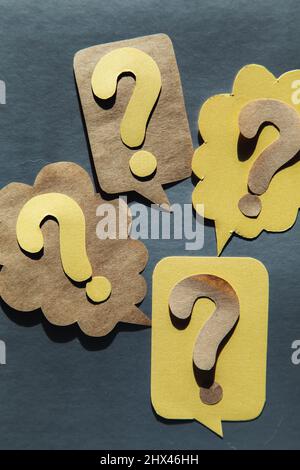 Question mark on speech bubbles, gray background. View from above. Problem and solution concept. Brainstorm. Stock Photo