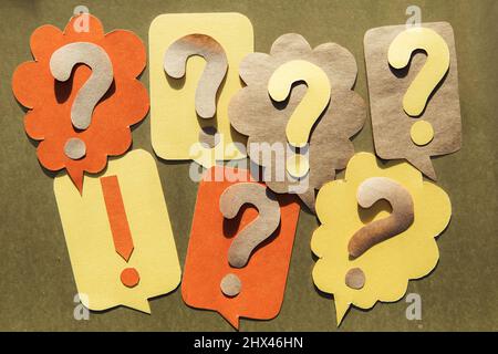 Question mark on speech bubbles, golden background. View from above. Problem and solution concept. Brainstorm. Stock Photo