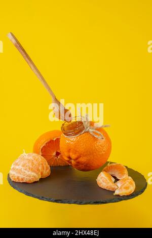 Mandarin orange jam in a little orange jar, with mandarin wedges Stock Photo
