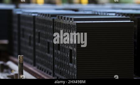 Plant for production of ceramic building blocks, professional technology. Working machinery and many rows of raw construction blocks on a conveyor bel Stock Photo