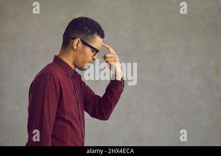 Young african american man thinking put finger to forehead studio portrait Stock Photo