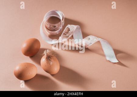 Happy Easter card with natural color eggs and feathers on beige background Stock Photo